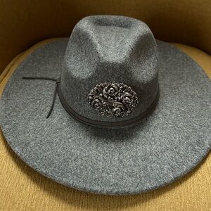 Grey fedora hat with large floral pin.